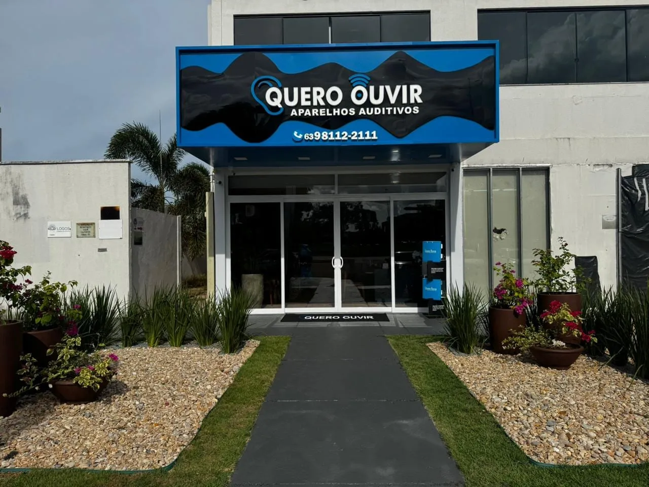 Fachada da Quero Ouvir em Palmas, com caminho de entrada e jardim